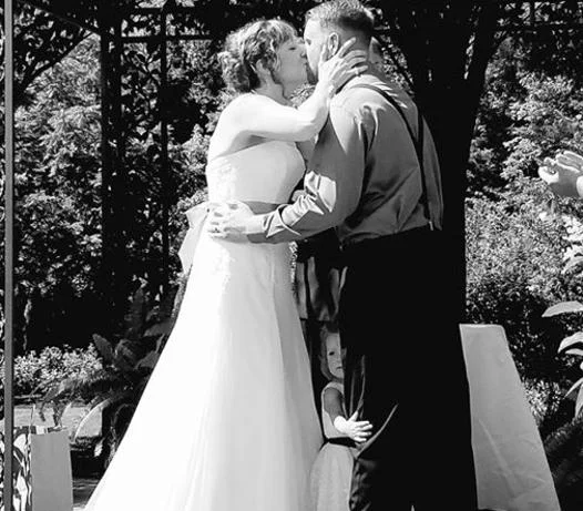 Black and white photo of a bride and groom kissing