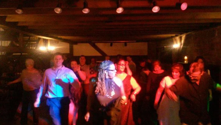 Guests dancing under colorful party lights
